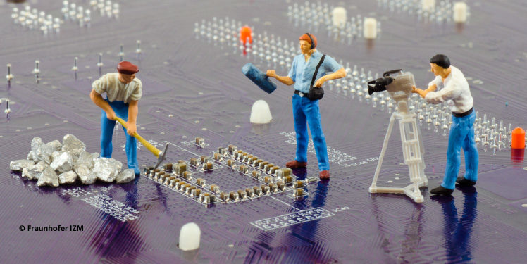 Circuit board with miniature construction workers and camera crew, Fraunhofer IZM